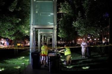 Workers clean up broken glass after the Holocaust Memorial was vandalized in Boston